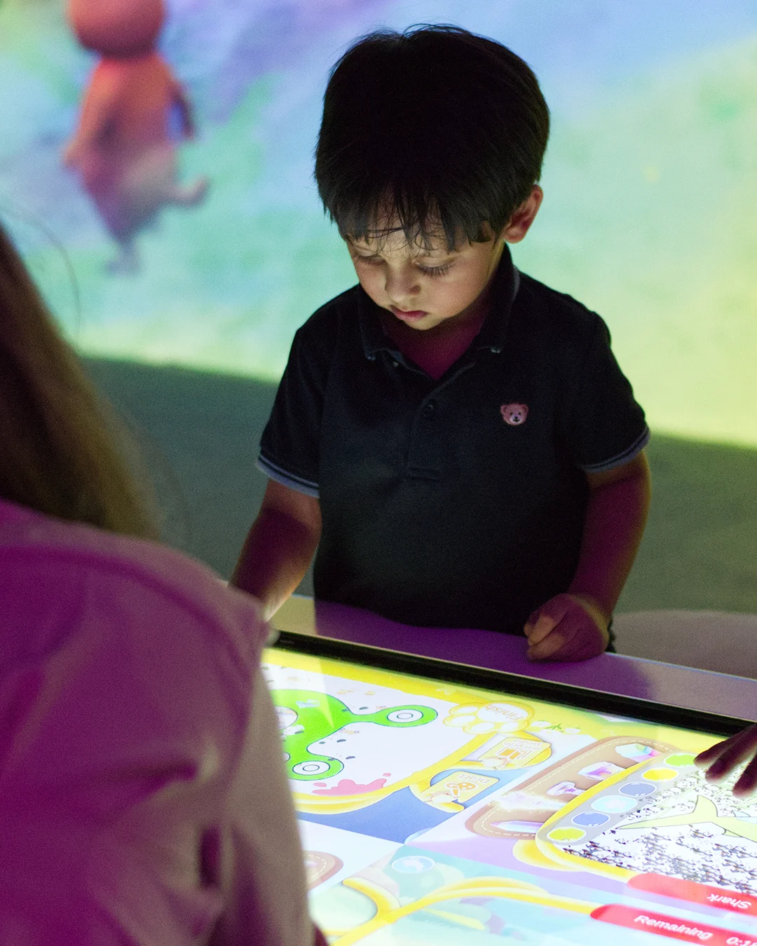 Child creating artwork on a touchscreen in E-Magine