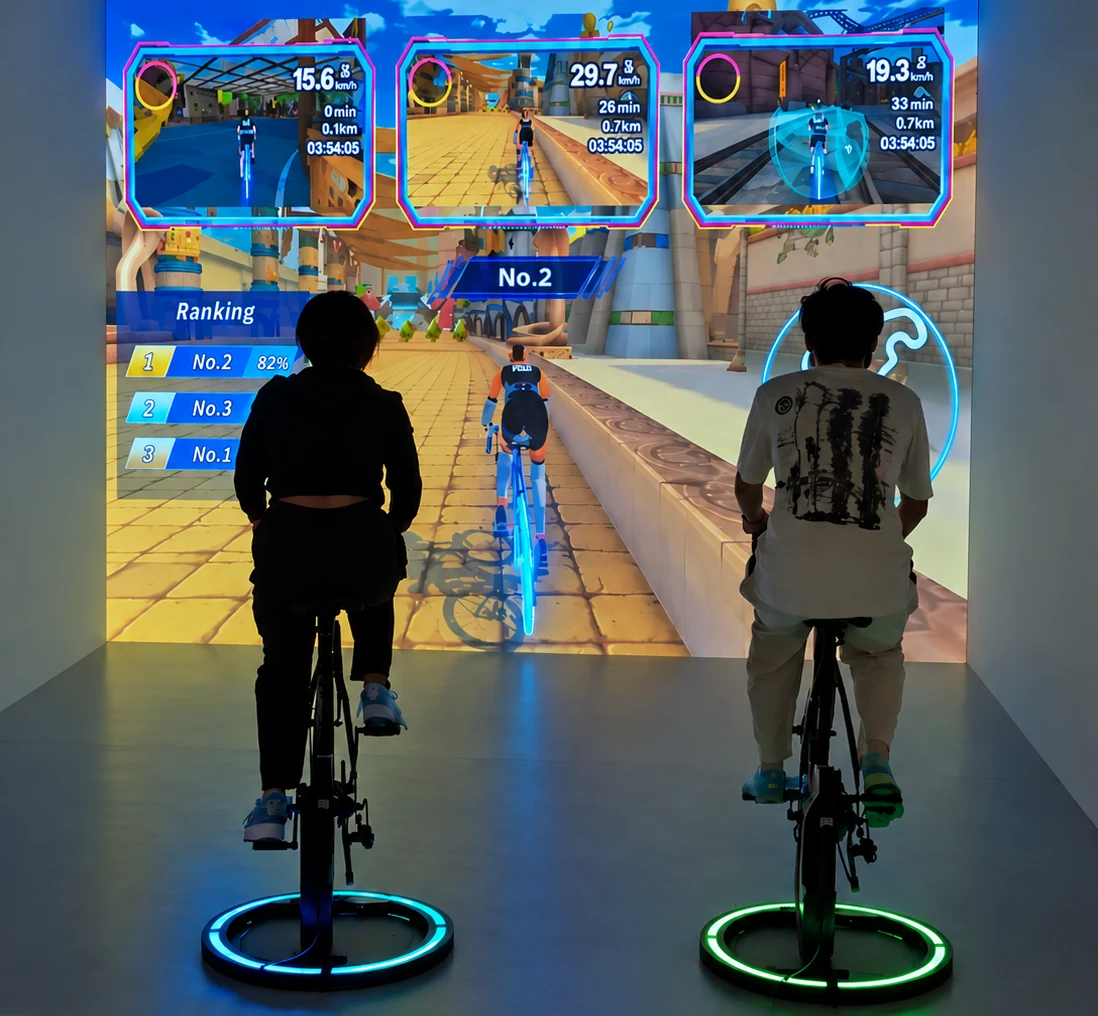 Two visitors racing exercise bikes through a virtual world in The Trip