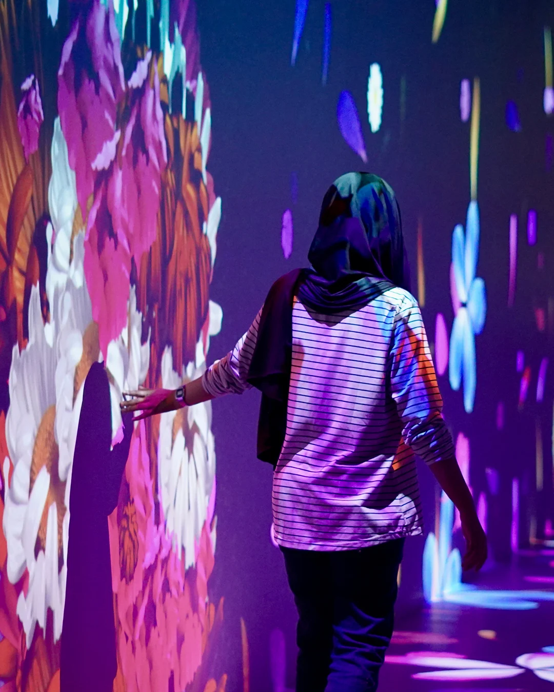 Visitor touching a colourful interactive projection in The Tunnel